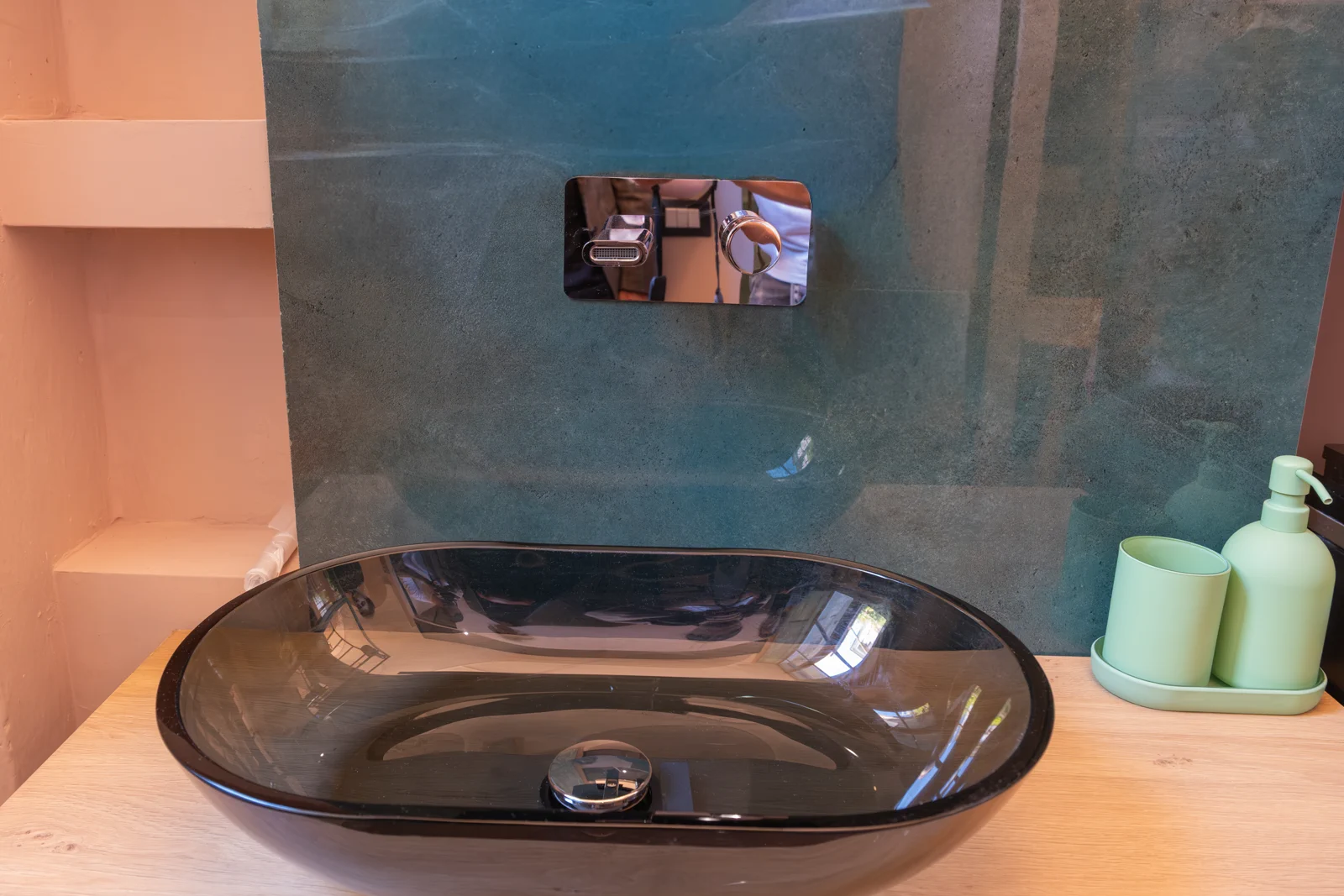 Bagno di design con lavabo in vetro e marmo verde